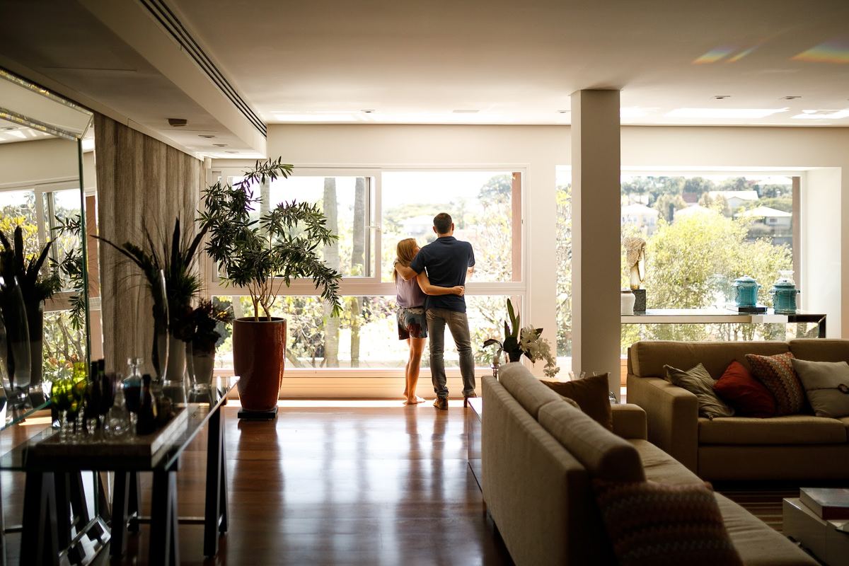 A couple looking out from the living room of their home